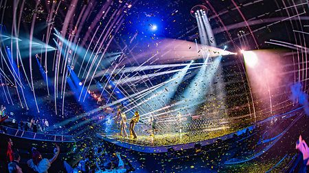 A vibrant Eurovision performance with confetti and a live band using Claypaky equipment for capturing the show