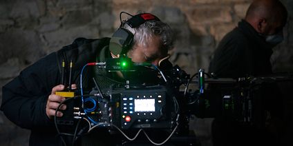 DP works with digital movie camera on the film set. 
