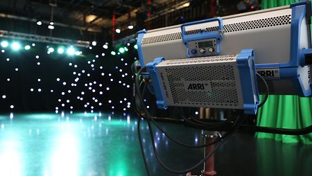 A SkyPanel LED light in front of a ARRI Solutions production setup. 