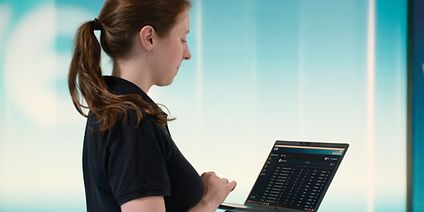 Image of a woman checking the integrated-studio settings via a laptop.