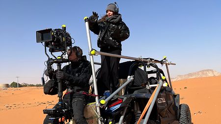 TRINITY Operator Torben Meldgaard in the middle of the desert, holding ARRI stabilizer TRINITY 2 while sitting on a vehicle 