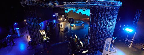 Image of the ARRI stage london filming a virtual production scene including a car on the stage in front of a dynamic background.