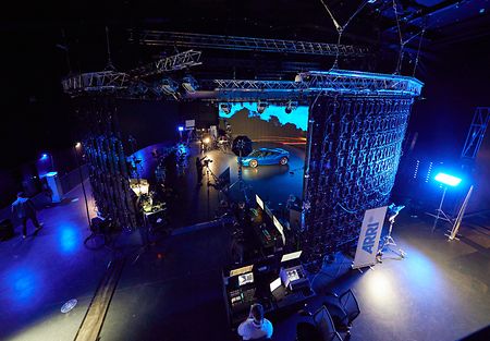 Image of the ARRI stage london filming a virtual production scene including a car on the stage in front of a dynamic background.