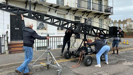 Cinematographer Roger Deakins (left) helping to move a crane on location.