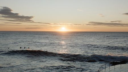 A picture of the sun setting over the Pacific Ocean on the coast of Australia
