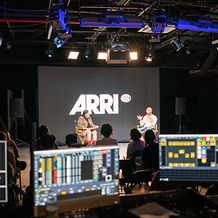 Two individuals seated on a stage set up by ARRI Solutions at ARRI Studio NY
