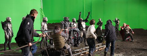A film set with around 12 people, 4 of those are crew. ALEXA Plus on a dolly in front of a greenscreen.